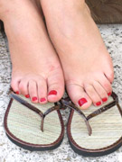 Knockout tart in flip flops displaying her yummy feet with red toe nails.