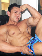 Sexy asian bodybuilder posing to flaunt his pumped muscular body