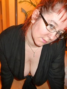 Lovely blonde secretary in glasses, stockings and white high heels demonstrating her naked cooch sitting on her desk