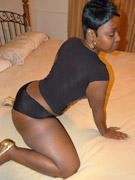 Nasty black housewife in black panties teasing on the bed.
