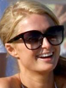 Paris hilton having fun on the beach in sunglasses and white bikini