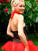 Sexy naughty blonde in pretty red and black dress enjoys looking sexy outdoors