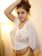 Curvy brunette teen posing in a white transparent blouse