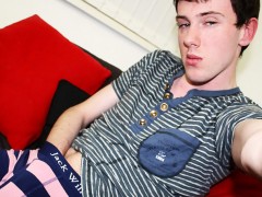Horny twink in a striped polo turns on his laptop and pounds his ass with a huge dildo in front of it