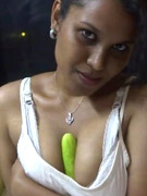 Indian hottie wearing white dress shows how big her tits are as she squeezes a big cucumber between her cleavage.