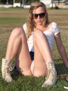 Nasty blonde teen girl in a blue skirt and boots in the park