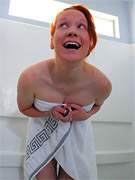Fresh after shower naked redhead beauty moisturizing her perfect body with oil.
